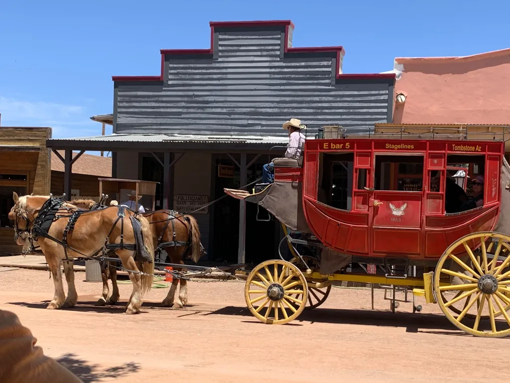 Red stagecoach with horses in dusty street